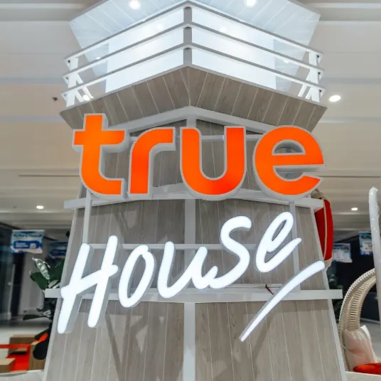 ป้ายแบรนด์ 'true HOUSE' ตกแต่งด้วยไม้และไฟส่องสว่างภายในพื้นที่องค์กร ผลงานออกแบบภายในโดย OBJ Design & Build