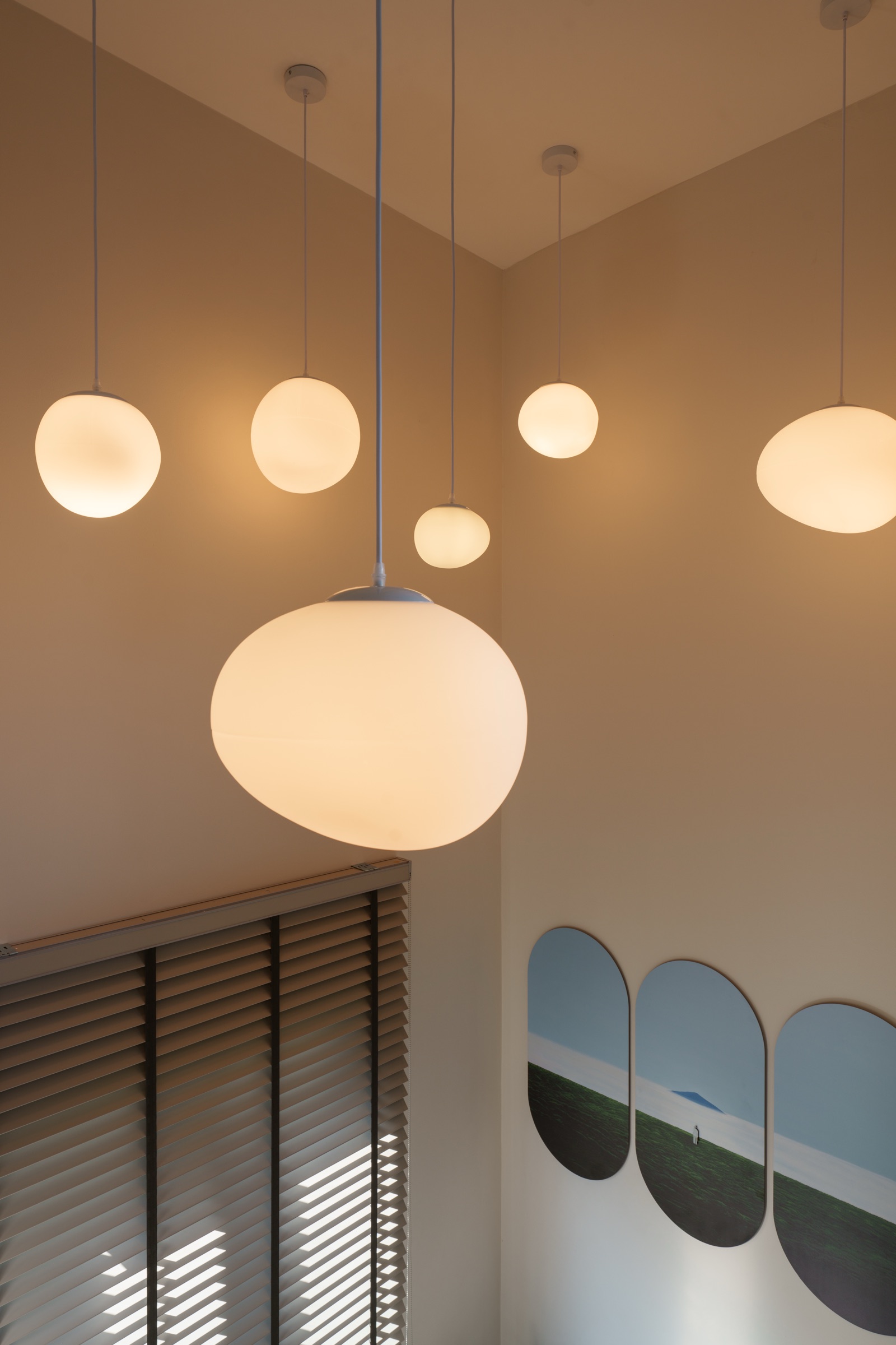 โคมไฟแขวนทรงกลมกระจายหลายดวง เหนือชานพักบันได ผลงานออกแบบภายในโดย OBJ Design & Build